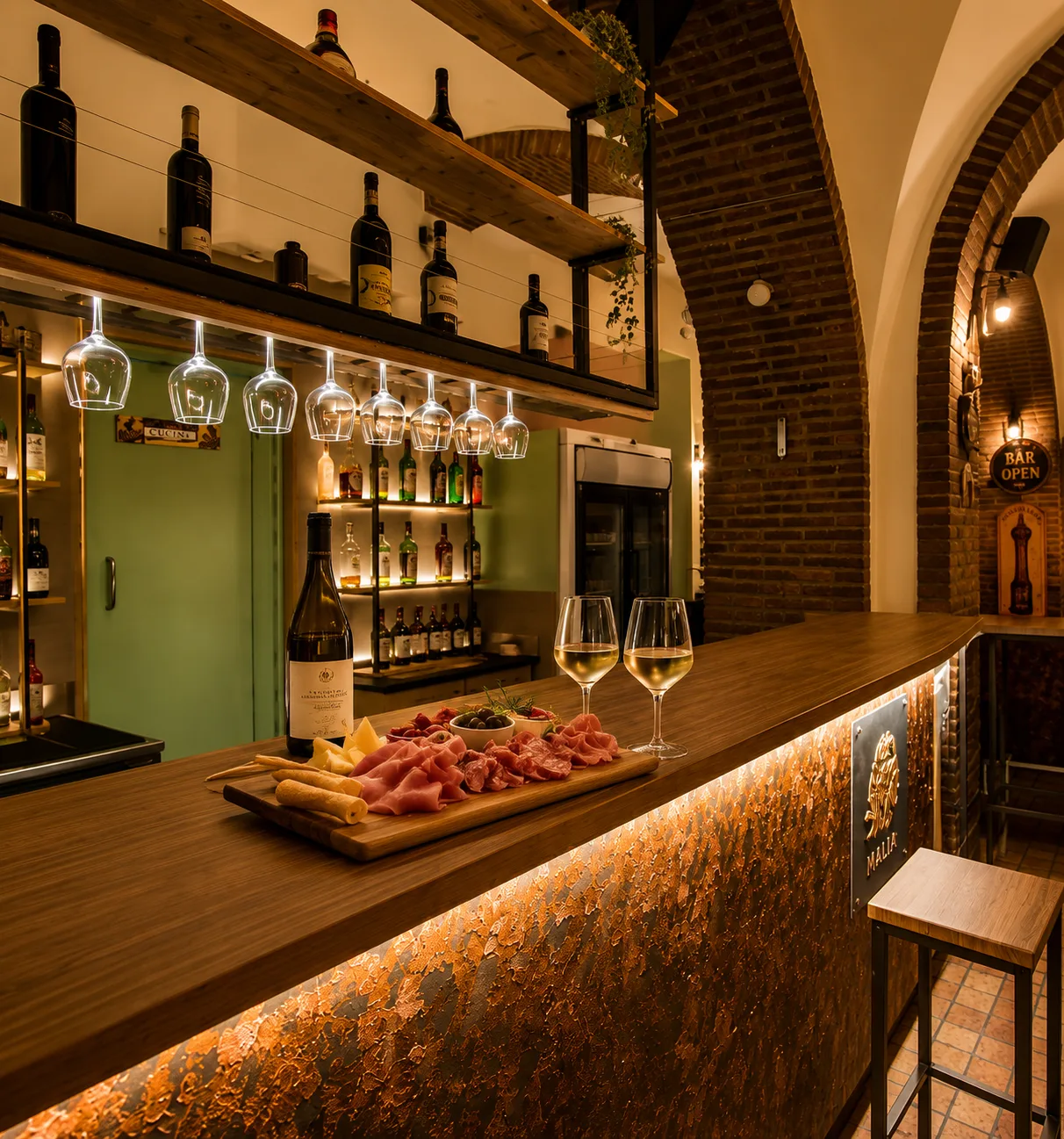 Dettaglio bancone bar – Pub Malìa Dettaglio del bancone bar in legno con illuminazione LED integrata, piano effetto ruggine e retrobanco su misura realizzato da Skenarte per il Pub Malìa.